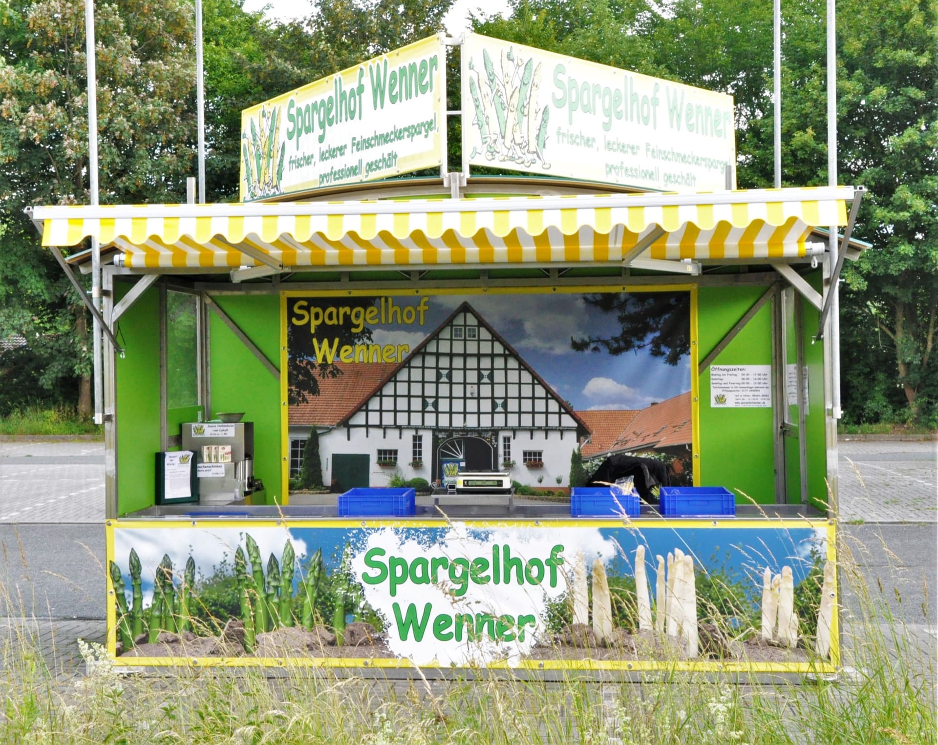Ein Verkaufsstand des Spargelhofs Wenner von vorn, grün mit gelb-weiß gestreifter Markise